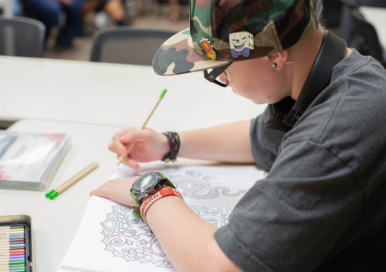 Student coloring a coloring book in the ARISE Lab.